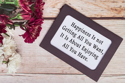 Motivational quote on chalkboard frame and white flowers on on wooden desk. photo