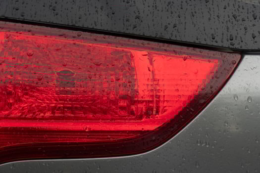 Close up tail light red color. Car gray color. On the boy with drop of rain. photo