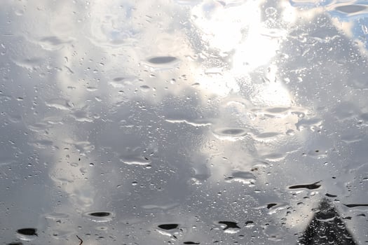Rain drops running down a car window in a close up view. photo