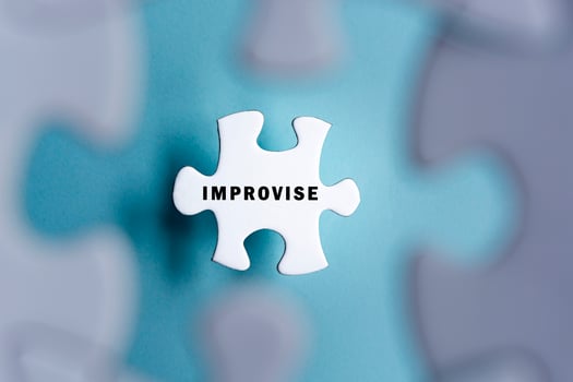 Improvise word on puzzle pieces isolated on blurred blue background. photo
