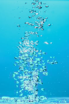 Abstract background image of bubbles in water. Clean water with water droplets and waves. Fresh water a glass with bubbles blue background. photo