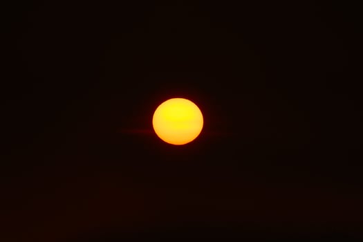 Orange sun in the dark sunset sky photo
