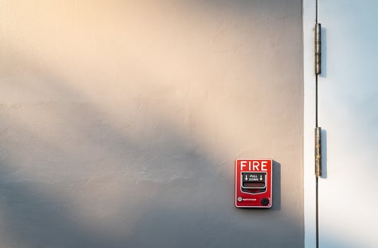 Fire alarm on dark gray concrete wall. Warning and security system. Emergency equipment for safety alert. Red box of fire alarm on wall of school, hospital, factory, office, apartment, or home. photo