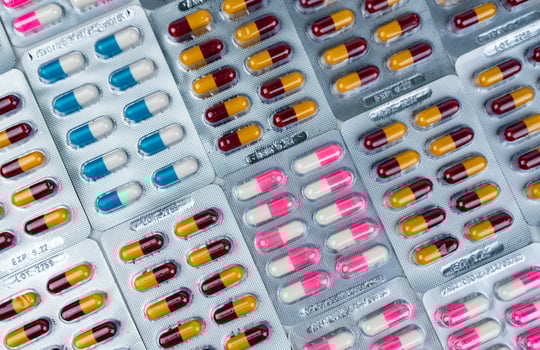 Top view of colorful antibiotic capsule pills in blister pack. Antibiotic drug resistance. Pharmaceutical industry. Pharmacy drug store background. Global health care.  Antimicrobial capsule pills. photo