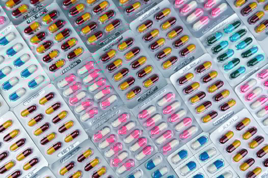 Top view of colorful antibiotic capsule pills in blister pack. Antibiotic drug resistance. Pharmaceutical industry. Pharmacy drug store background. Global health care.  Antimicrobial capsule. photo
