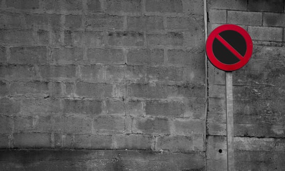 No parking sign. Regulatory sign. Circle red and black no parking sign on post. Traffic sign on gray and white brick wall texture background. Road signs for prohibit car parking. Restrictive signs. photo
