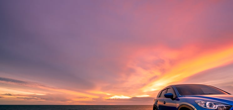 Blue compact SUV car with sport and modern design parked by beach at sunset. Hybrid and electric car technology. Car parking space. Automotive industry. Car care business background. Beautiful sky. photo