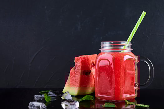 Fresh delicious watermelon smoothie with ice on dark background photo