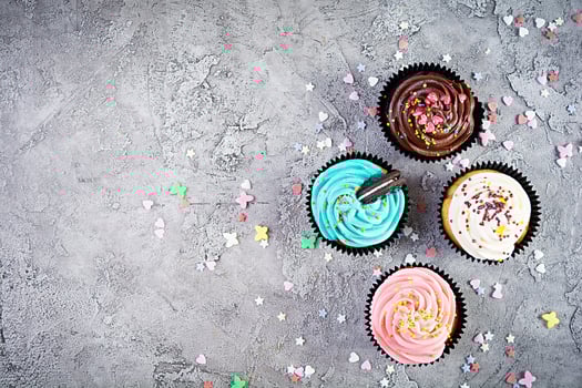 Tasty colorful cupcakes isolated on grey background. Delicious cupcake photo