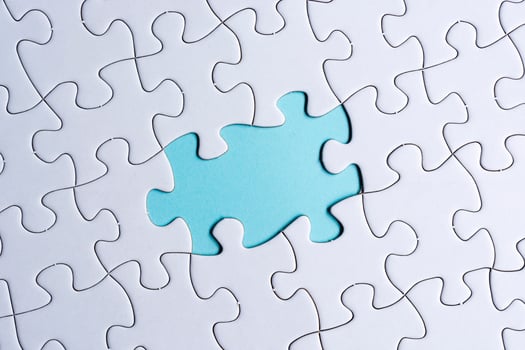 Piece of jigsaw puzzle on blue paper. Directly above. Copy space. photo