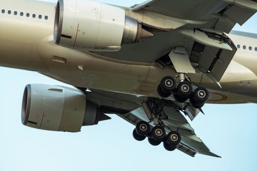 Closeup rubber wheels and chassis of commercial airline. Passenger plane landing or take off. Aerospace Engineering. Airplane flying on blue sky. Aircraft engine detail at landing or takeoff. photo