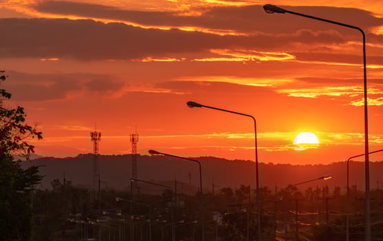 Beautiful sunrise over mountain in the morning. View from the road and electric pole and cable wire. Beautiful scene between travel in the morning. Big sun rise in the morning among clouds. Valley. photo