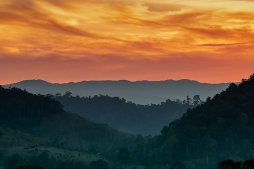 Beautiful nature landscape of mountain range with sunset sky and clouds. Mountain valley in Thailand. Scenery of mountain layer at dusk. Tropical forest. Natural background. Orange and golden sky. photo