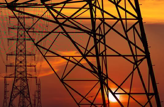 High voltage electric pole and transmission lines in the evening. Electricity pylons at sunset. Power and energy. Energy conservation. High voltage grid tower with wire cable at distribution station. photo