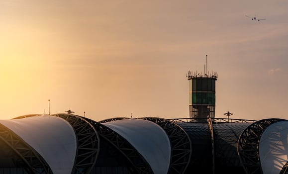 Airport roof and air traffic control tower in the airport with international flight plane flying on the sky. Airport traffic control tower for control airspace by radar. Aviation technology. photo