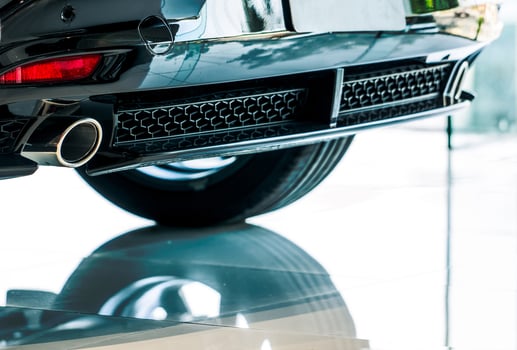 Closeup detail exhaust pipe of car that parked in showroom with reflection. Unique pattern of car exhaust pipe. Accessories for sports car. Exhaust pipe of gasoline engine car. Automobile rear grille. photo
