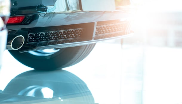 Closeup detail exhaust pipe of car that parked in modern showroom. Accessories for car. Exhaust pipe of gasoline engine car. Automobile rear grille. Automotive industry. Car service and maintenance. photo