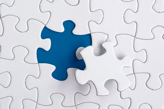 Piece of jigsaw puzzle on blue paper. Directly above. Copy space. photo