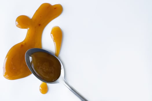 the drops of homemade sauce and a spoon on a white background photo