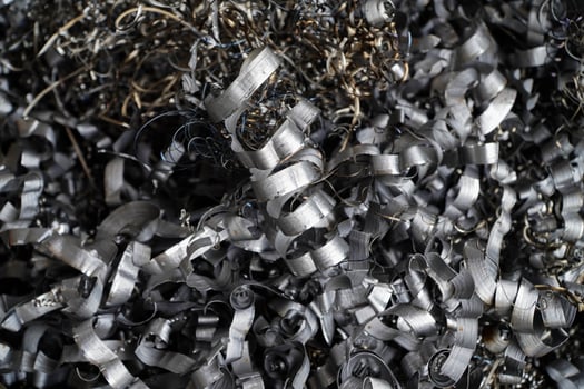 Steel scrap materials recycling. Aluminum chip waste after machining metal parts on a cnc lathe. Closeup twisted spiral steel shavings. Small roughness sharpness, photo