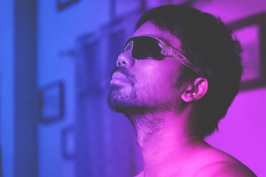Asian man on blue and pink studio background in mixed neon light photo