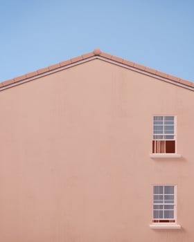 Gable house front view with pink wall and blue sky.Minimal concept.3d rendering photo