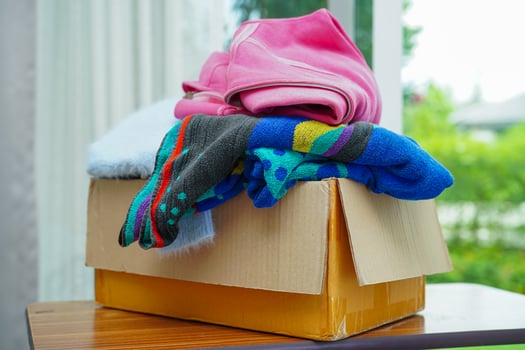 Clothes donations in cardboard box for volunteer. photo