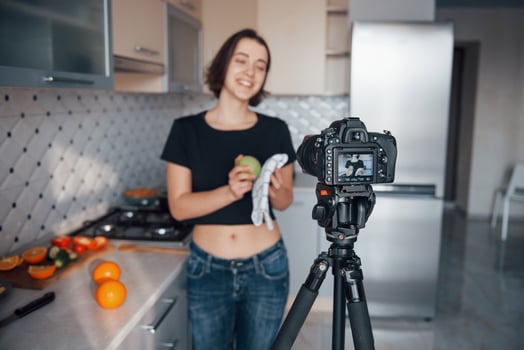 Just posing for the camera and making some food of fruits. Girl in the modern kitchen at home at her weekend time in the morning photo