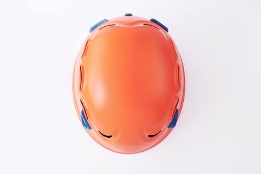 Top view. Isolated photo of climbing equipment - orange colored protective helmet