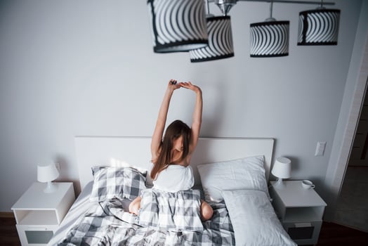 Interesting lamps. Pretty young woman lying on the bed at morning time in her room photo