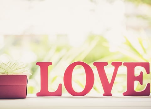 Word LOVE wooden text and gift box with bow ribbon on wood table vintage retro tone, present of romantic day, sign and romantic of Valentine, holiday concept. photo
