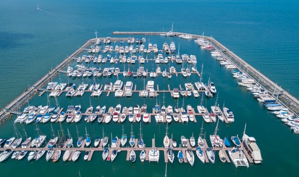 Marine port for yacht, motorboat, sailboat parking service and moorings for luxury and wealthy millionaire in aerial view with many ships anchoring along the dock bay photo