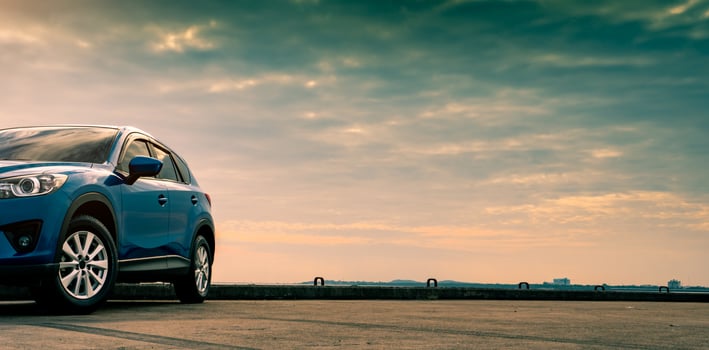 Blue compact SUV car with sport and modern design parked on concrete road by the sea. Hybrid and electric car technology concept. Car parking space. Automotive industry. Car care service concept. photo