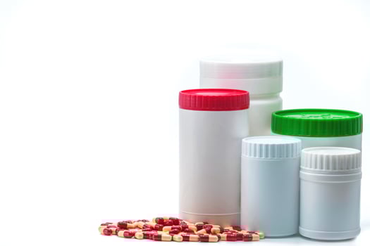 Antibiotic capsule pills with blank label plastic bottle container isolated on white background. Pharmaceutical industry. Pharmacy background. Antimicrobial drug resistance. Global healthcare concept. photo