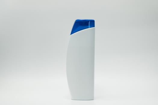 Shampoo or conditioner bottle with blue dispenser pump isolated on white background with blank label and  copy space. Use for advertise shampoo or conditioner. Cosmetic product package. Beauty product photo