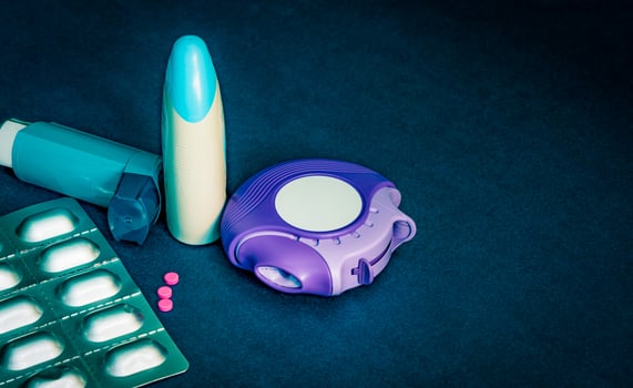Set of asthma inhaler, accuhaler and anti-allergy pills for treatment asthma. Asthma controller, reliever equipment on blue table with copy space. Bronchodilator and steroids drug for severe asthma. photo
