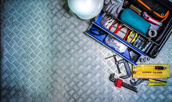 Top view of tools box and helmet on checkered plate background in workshop. Service tools set. Home building and electrical tools. Plumber hand tools. Technician equipment for repair work. photo