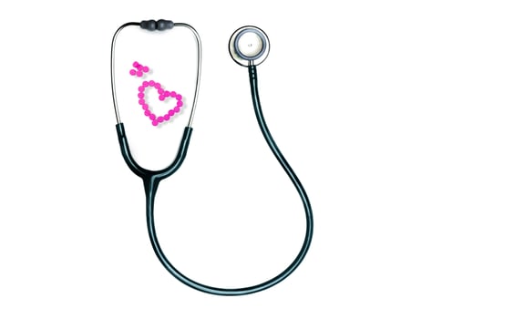 Green stethoscope and pink tablets arrange in heart shape isolated on white background. Heartbeat check-up medical tool. Stethoscope of cardiology doctor. Warfarin tablets pills. Anticoagulant drugs. photo