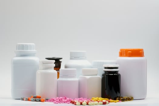 Colorful of tablets and capsule pill and plastic drug bottle on white background with blank label. Pharmaceutical industry. Pharmaceutical product. Pharmacy drugstore background. Drug interactions. photo