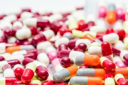 Selective focus on antibiotic capsule pills on blurred background of capsules. Pharmaceutical industry. Drug production. Global healthcare. Drug interaction. Antibiotic drug resistance and overuse. photo
