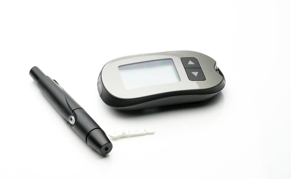 Medical equipment for measuring the level of blood glucose with lancing pen device on white background with copy space photo