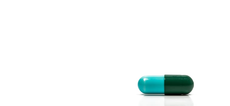 Blue, green antibiotics capsule pill isolated on white background with copy space. Drug resistance concept. Antibiotics drug use with reasonable and global healthcare concept. photo