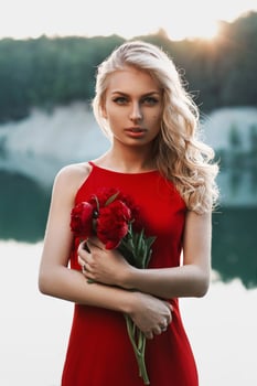 Beautiful woman with a bouquet of peony. photo
