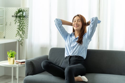Happy asian woman Relaxing Sitting On Sofa At Home, work from home concept. photo