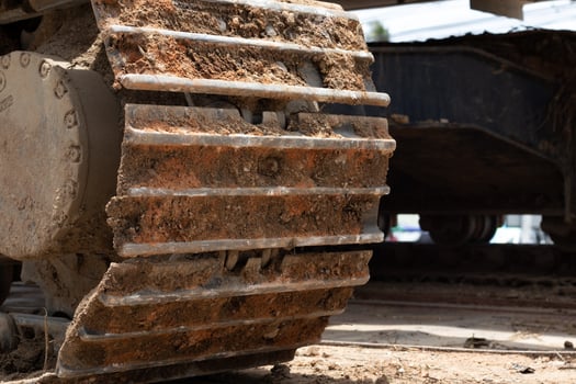 Close-up of a large  Dirty rear wheel of an excavator. Construction machinery. Detail of heavy tractor wheel photo