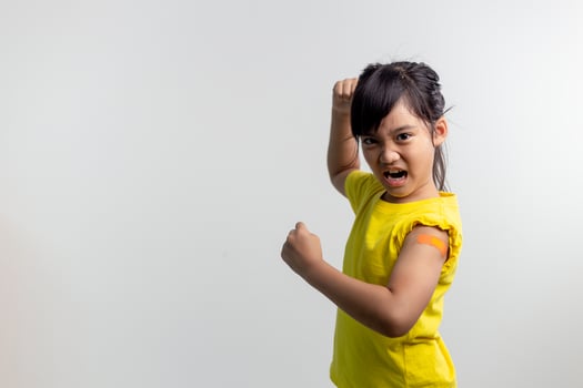 COVID 19 Vaccines for Kids concept. Studio a portrait of an adorable Asian girl after getting his first dose of vaccine. Immune, Safe, Available, Back to school. photo
