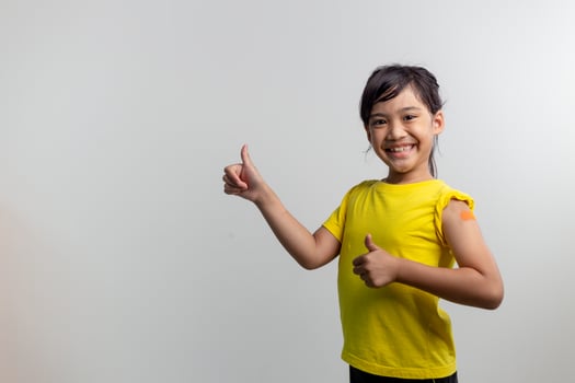 COVID 19 Vaccines for Kids concept. Studio a portrait of an adorable Asian girl after getting his first dose of vaccine. Immune, Safe, Available, Back to school. photo