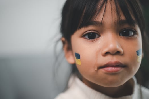 A child with the flag of Ukraine is crying. Sadness longing hope. Children's tears from the war. Evacuation of civilians. Freedom to Ukraine photo