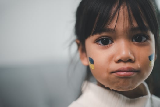 A child with the flag of Ukraine is crying. Sadness longing hope. Children's tears from the war. Evacuation of civilians. Freedom to Ukraine photo