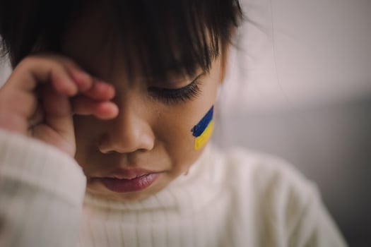 A child with the flag of Ukraine is crying. Sadness longing hope. Children's tears from the war. Evacuation of civilians. Freedom to Ukraine photo